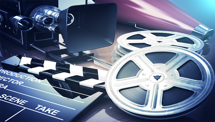 A film clapper board sits to the left of two movie reels.