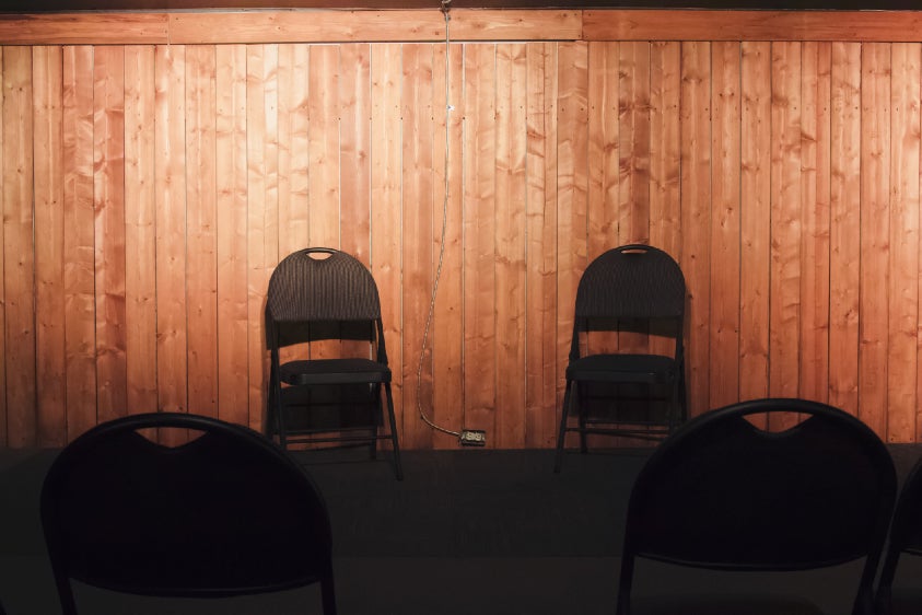 Two folding chairs on a stage.