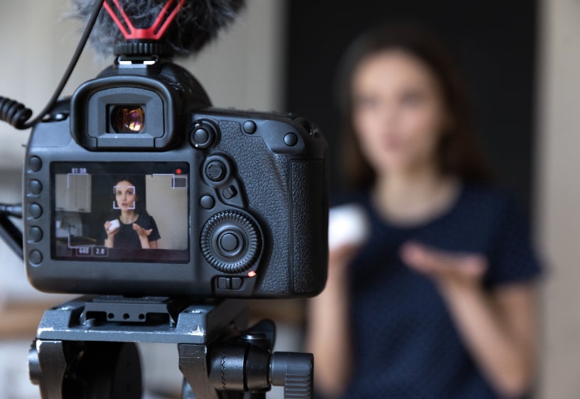 A person in front of a recording camera.