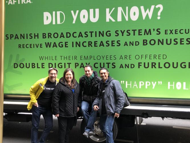 "Did You Know? Spanish Broadcasting System's Executives receive wage increases and bonuses while their employees are offered double digit pay cuts and furloughs. "Happy" Holidays" on the side of an ad truck with members posing in front.