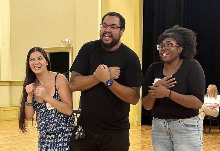 Three people stand side by side, crossing their arms across their chests.