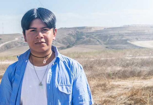 Image of a younger gentlemen standing in front of open land.