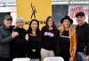 Four women and two men in dark clothing stand in front of a yellow SAG-AFTRA banner.