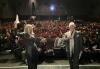 Hammel and Baron stand on the stage with the audience in the background.