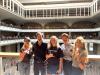 Five people dressed casually smile on the second floor of an atrium at the Hawaii Capitol.